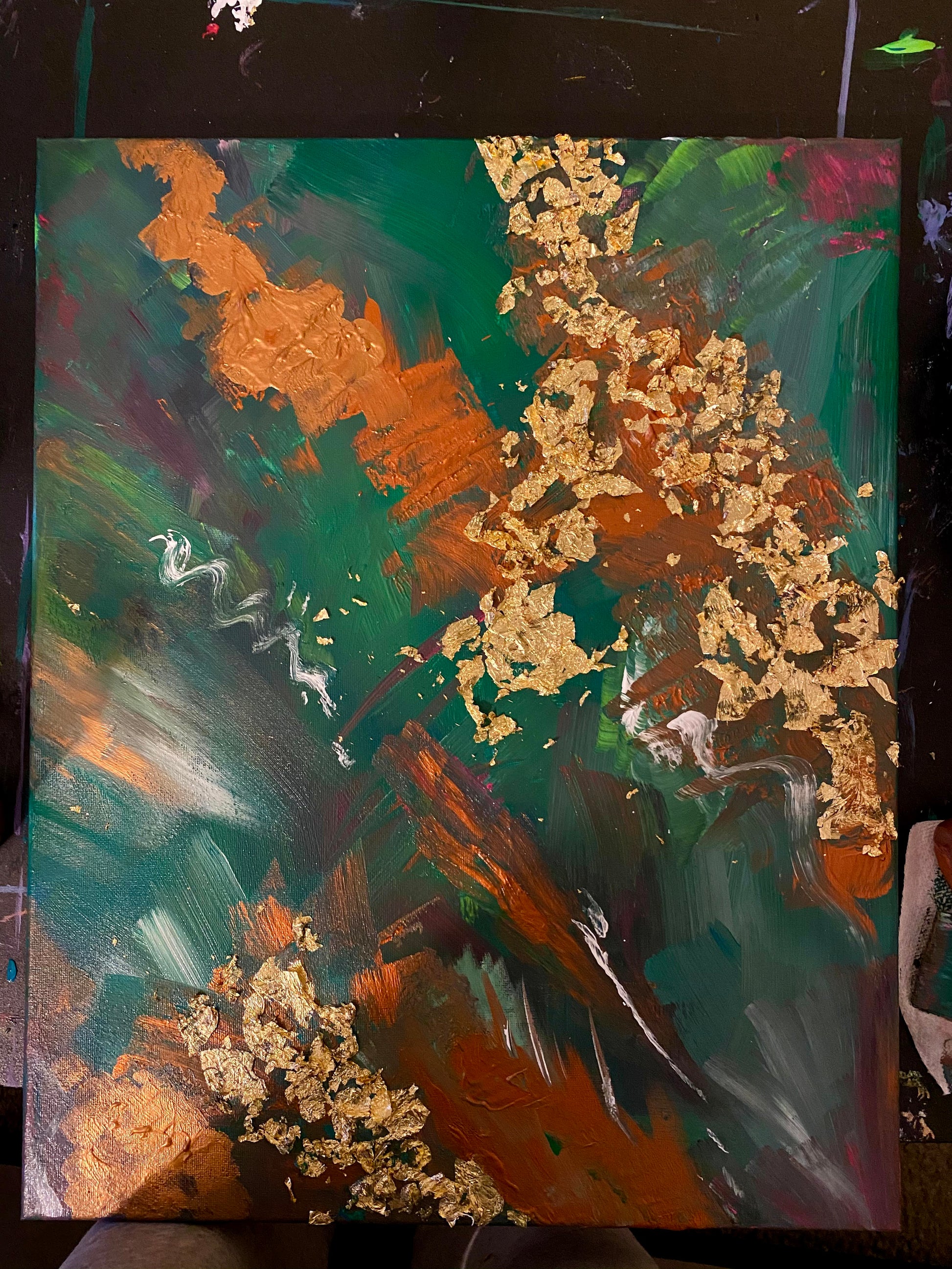 Rich emerald greens collide with molten copper strokes in Verdant Ember, creating a striking play between earth and fire. Layers of texture and metallic gold leaf catch and shift with the light, giving the painting an ever-changing depth depending on the viewer’s angle.

